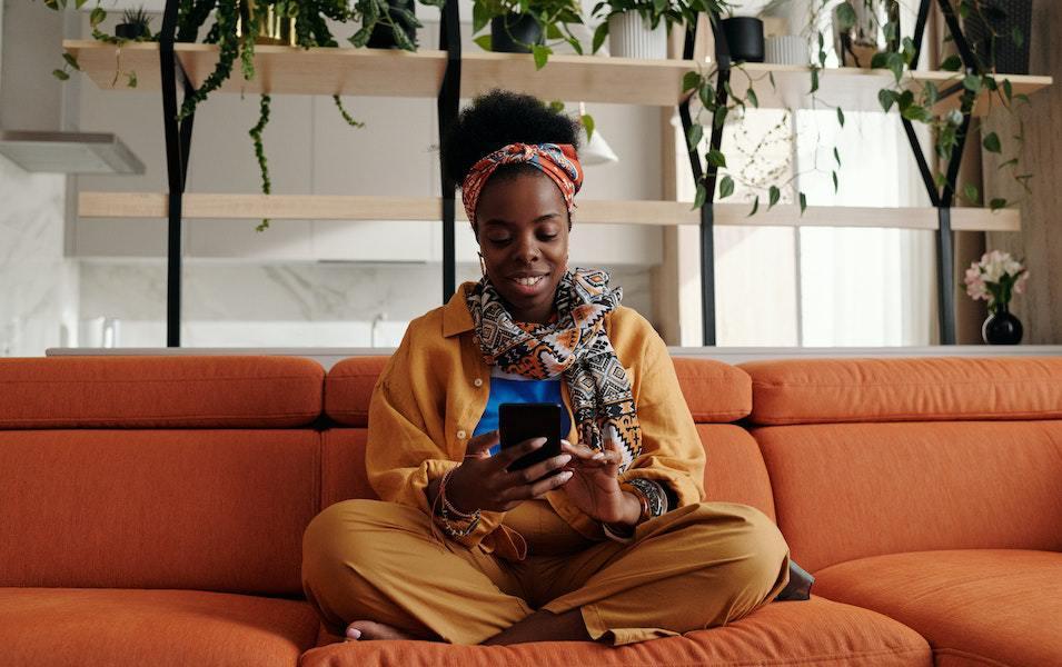 Woman sitting on couch texting