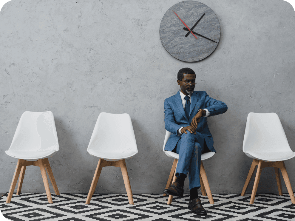 Man sitting in waiting room looking at his watch