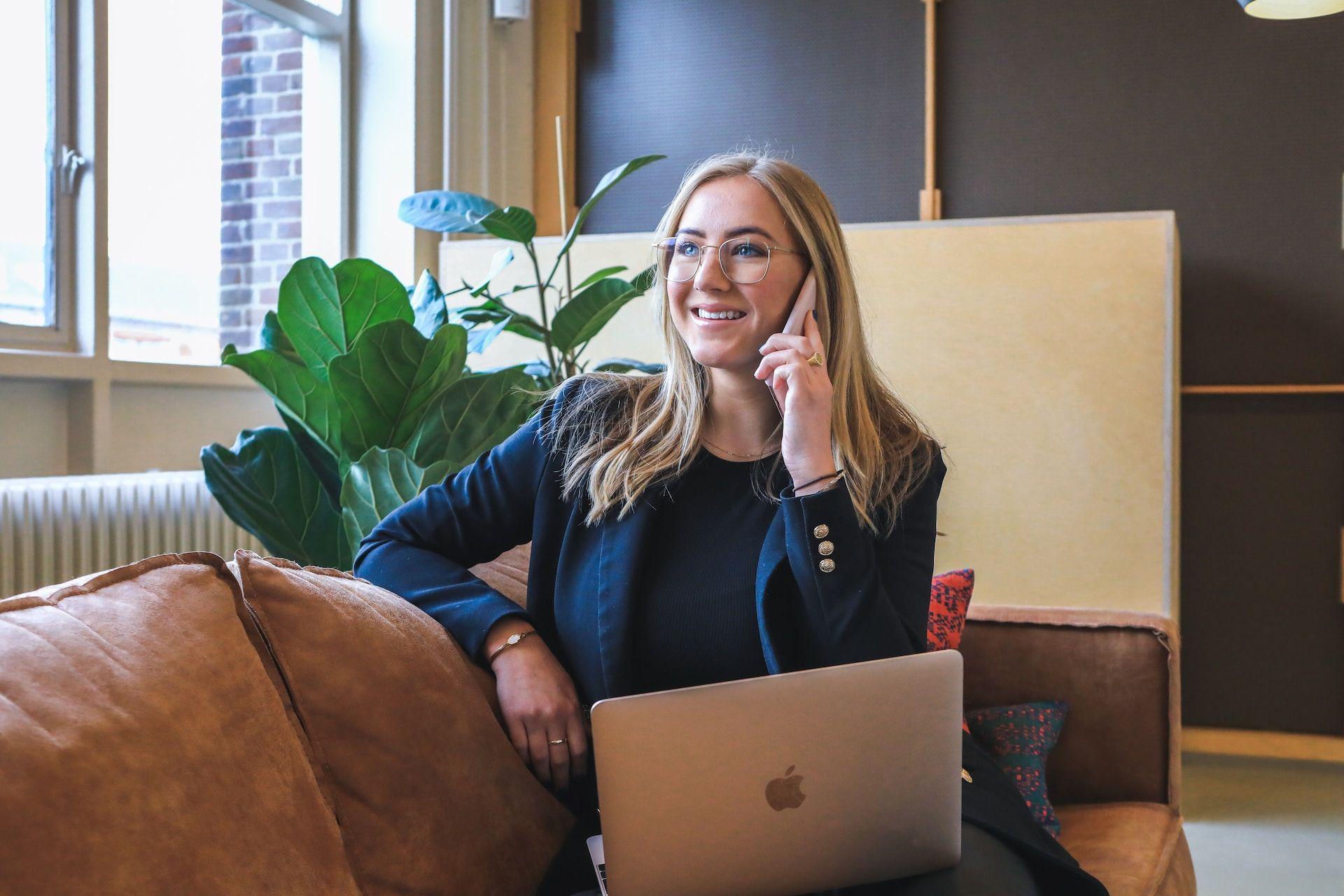 Woman on phone and Macbook laptop