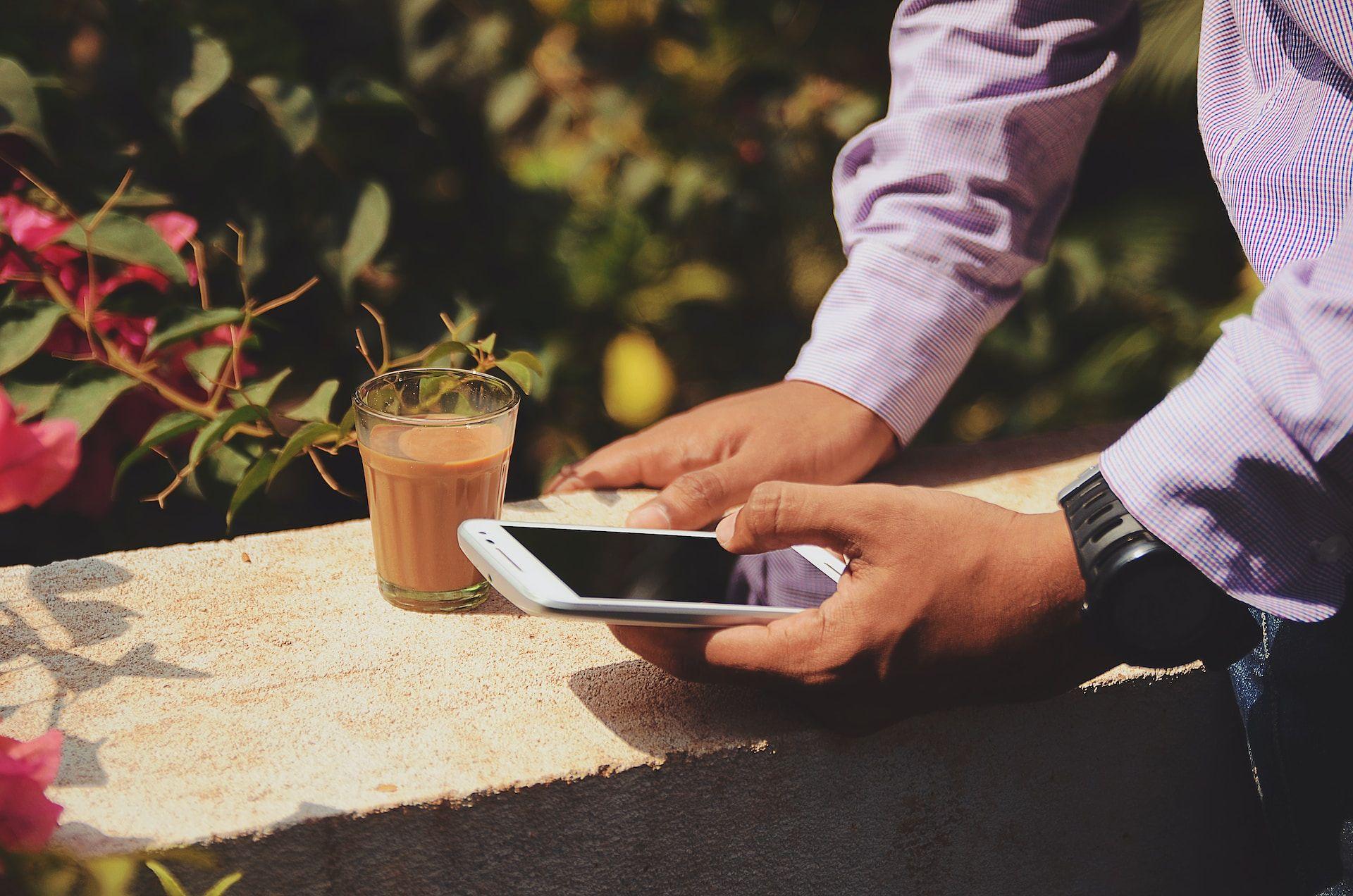 Man with phone and chocolate drink