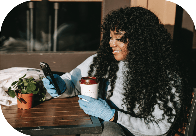 Woman uses SMS opt in on her mobile device while drinking tea