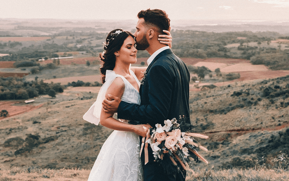 Groom kissing bride with beautiful background