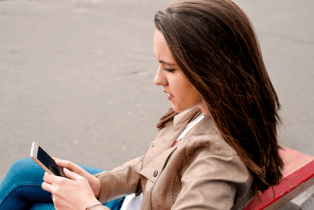 Woman outside texting sample text messages to customers