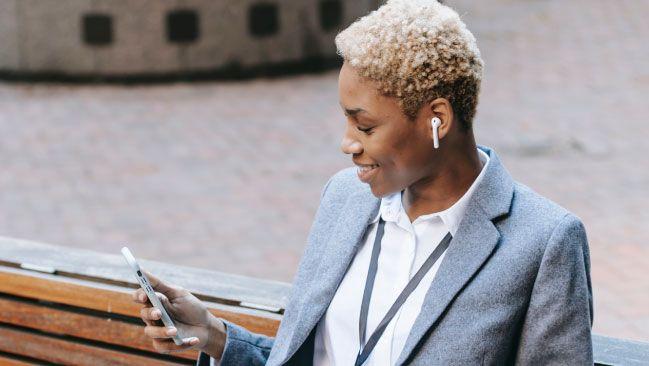 business woman texting sample text messages to customers outside
