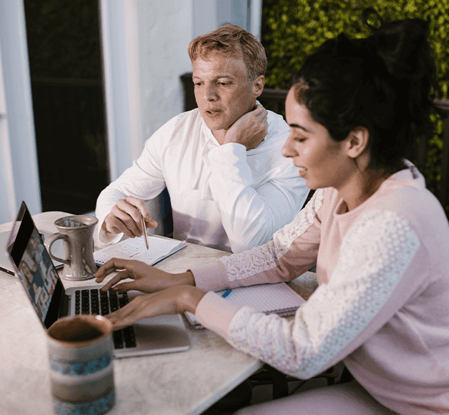 Man and woman viewing webinar on laptop