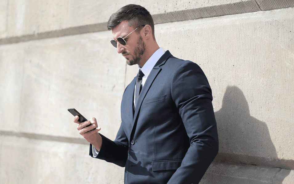 Businessman in sunglasses texting
