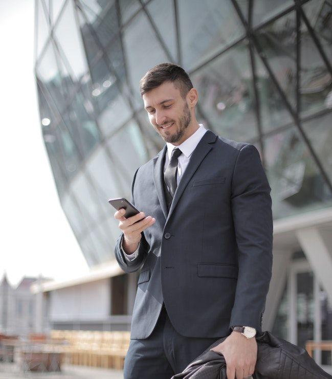 Businessman texting smart replies outside