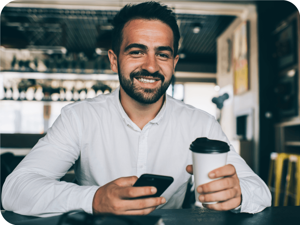 Man receiving an SMS while drinking coffee